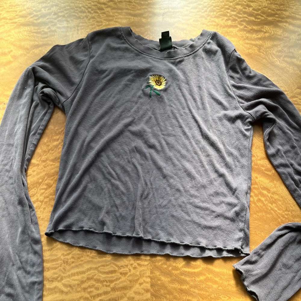 Long sleeved cropped top with flower on it.